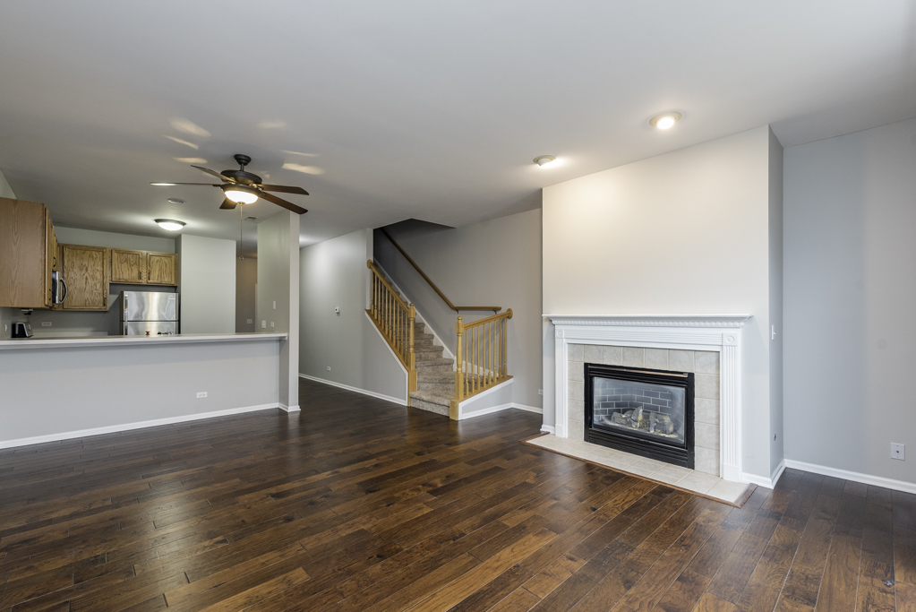 2879 Falling Waters Drive, Unit 2879 Lindenhurst, IL 60046 - Photo 4 of 30 a view of an empty room with wooden floor fireplace and a window