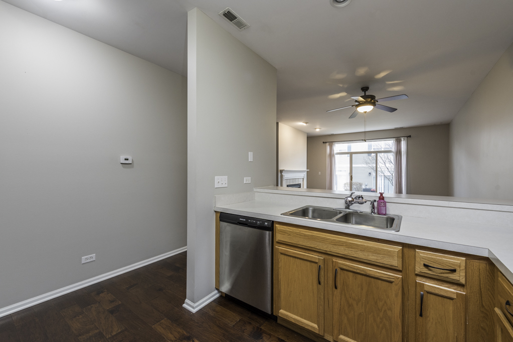 2879 Falling Waters Drive, Unit 2879 Lindenhurst, IL 60046 - Photo 9 of 30 a kitchen with a sink cabinets and a window
