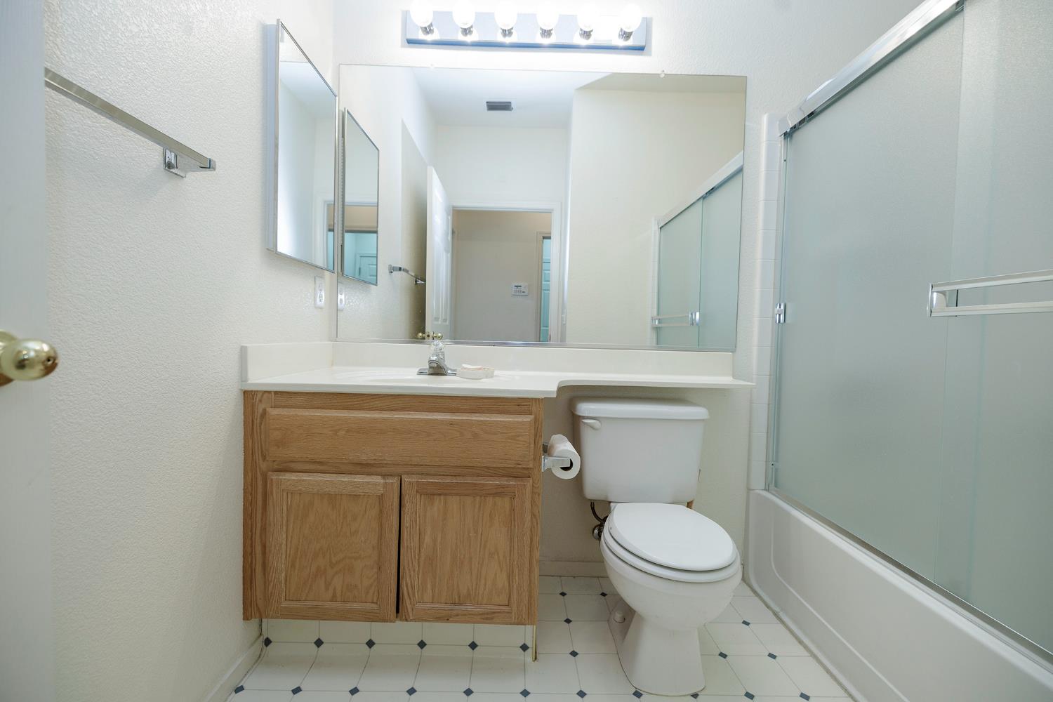 2123 Spring Blossom Lane Turlock, CA 95382 - Photo 21 of 44 a bathroom with a toilet a sink and mirror