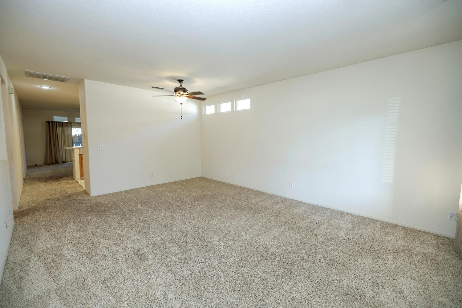 2123 Spring Blossom Lane Turlock, CA 95382 - Photo 9 of 44 an empty room with a chandelier fan and windows