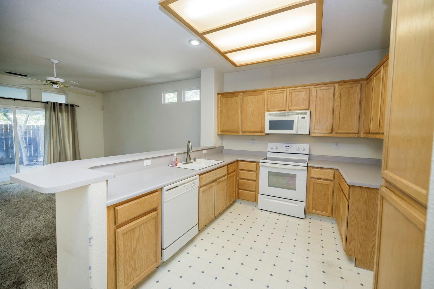 2123 Spring Blossom Lane Turlock, CA 95382 - Photo 10 of 44 a kitchen with granite countertop a sink stove and cabinets