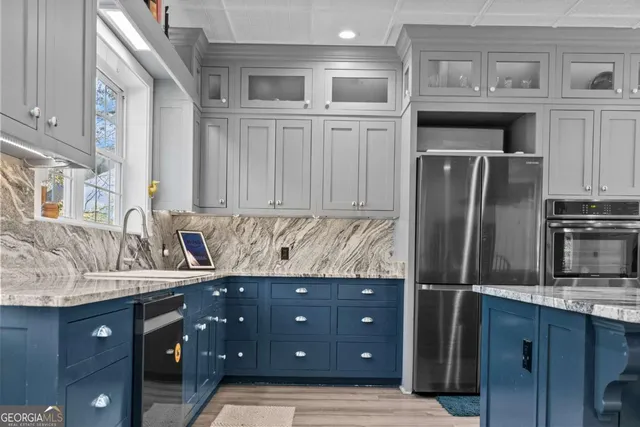 a kitchen with stainless steel appliances granite countertop a refrigerator and a sink