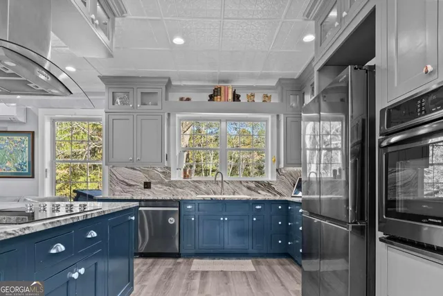 a kitchen with stainless steel appliances kitchen island granite countertop a refrigerator and a stove top oven