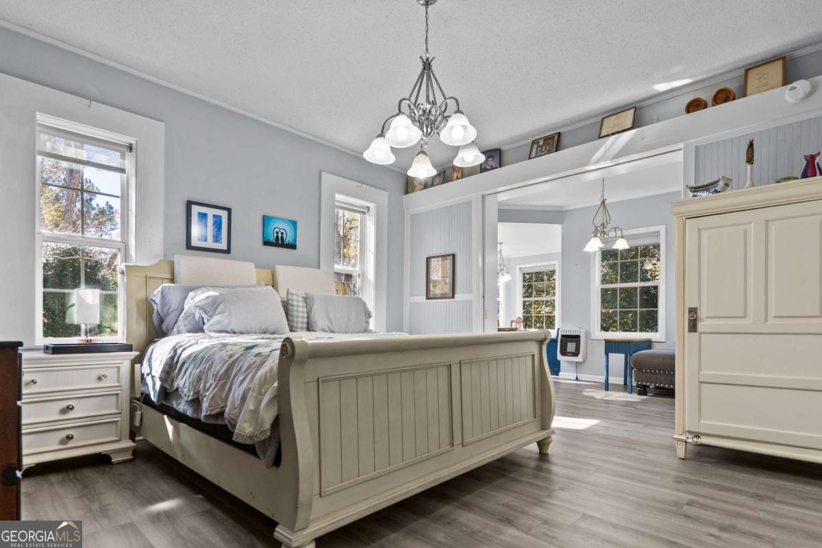 140 Jack Road Fitzgerald, GA 31750 - Photo 20 of 55 a bedroom with a large bed a chandelier and windows
