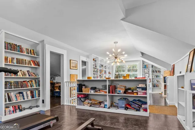 a living room with furniture a bookshelf and a window