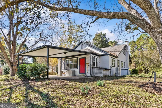 a view of a house with backyard and chairs