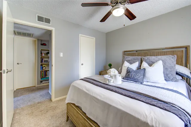 a spacious bedroom with a bed and a ceiling fan