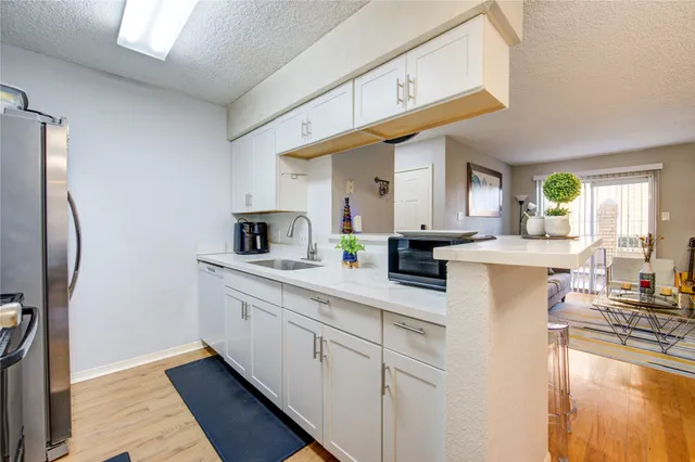 a kitchen with stainless steel appliances granite countertop a sink and a refrigerator