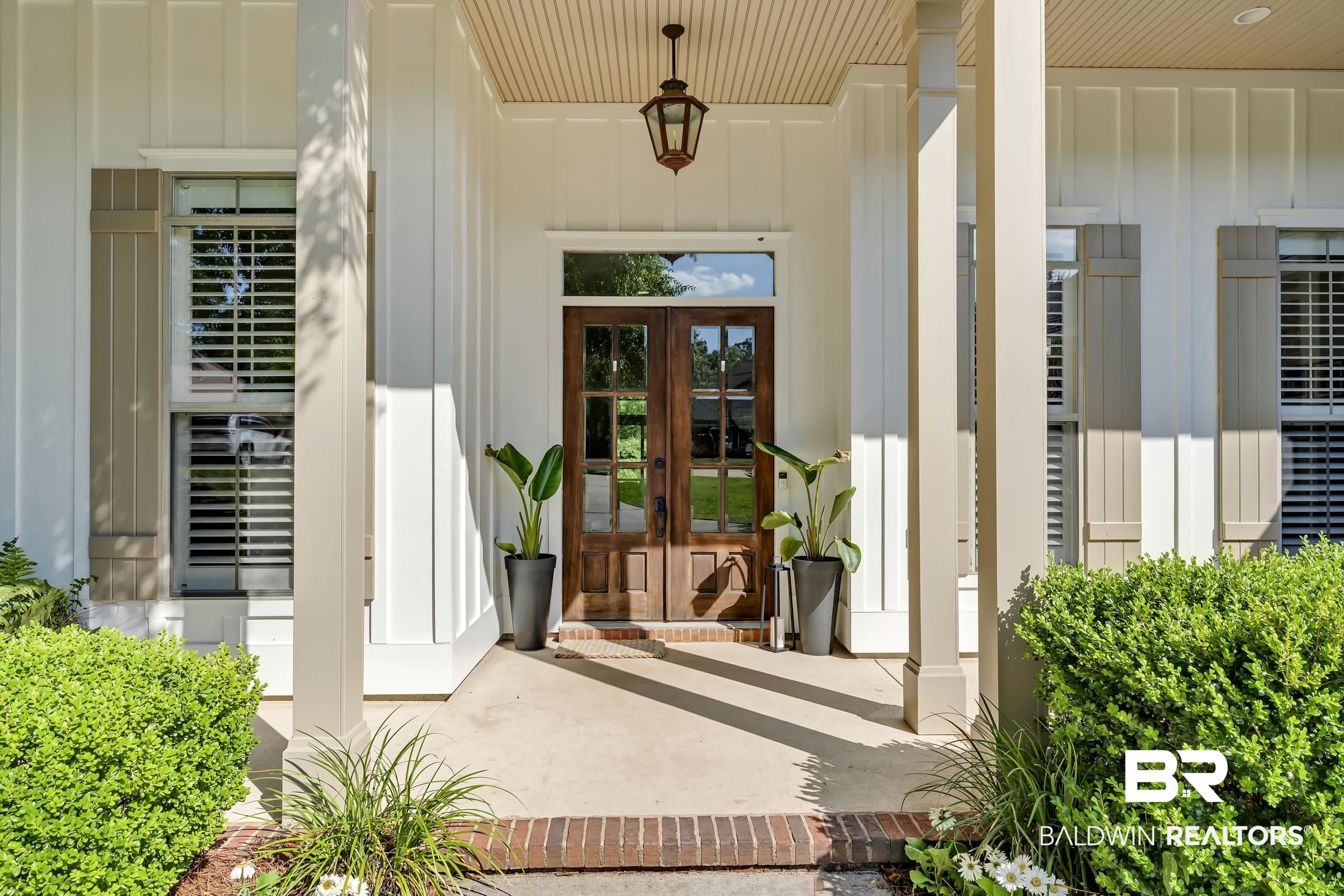 8137 Pine Run Daphne, AL 36527 - Photo 4 of 67 Architectural entry featuring double wood-panel doors with glass inserts, flanked by shuttered windows