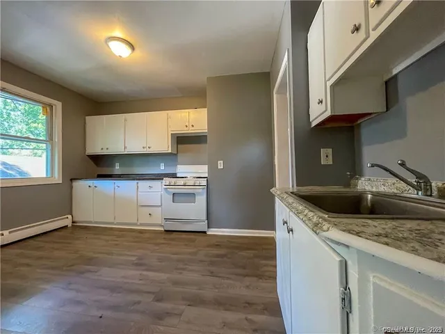a kitchen with stainless steel appliances granite countertop a sink stove and cabinets