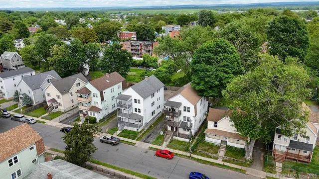 an aerial view of residential houses with outdoor space and trees