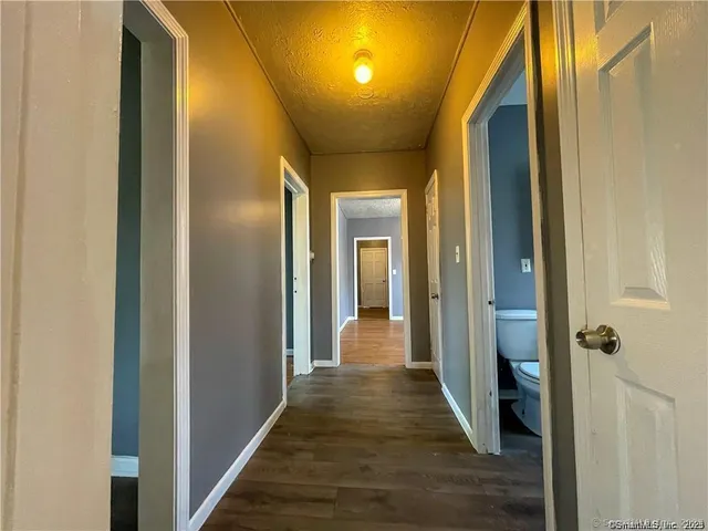 a view of a hallway with wooden floor and staircase