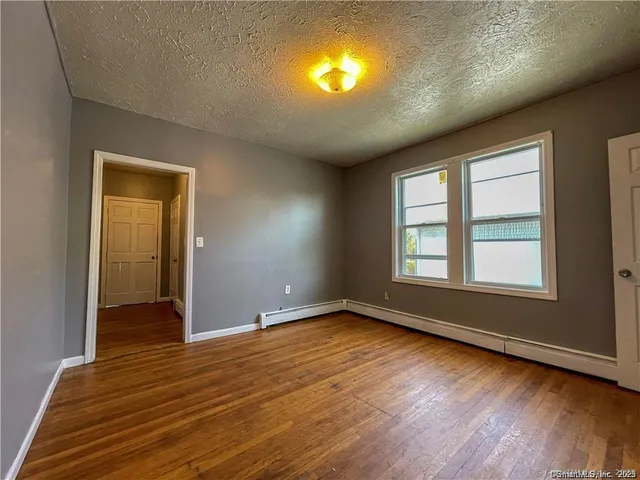 a view of room with window and wooden floor