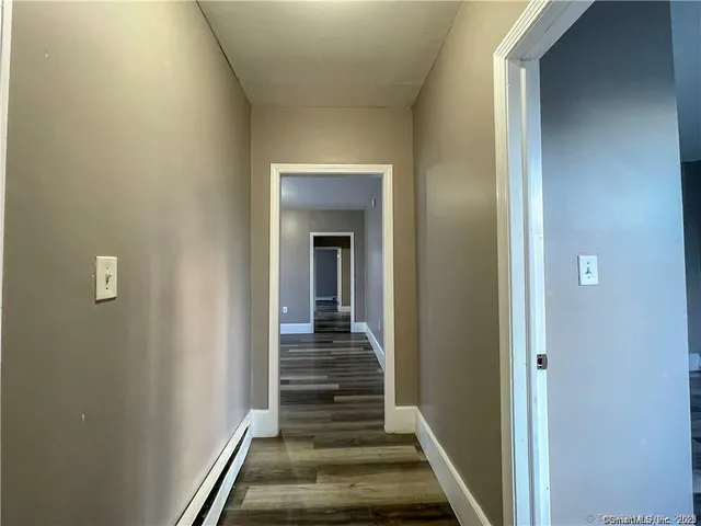 a view of a hallway with wooden floor and entryway