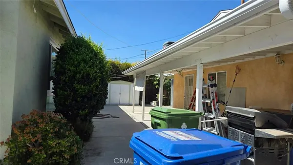 a view of a patio with table and chairs potted plants and floor to ceiling window