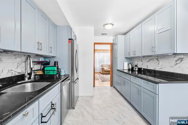 a kitchen with stainless steel appliances granite countertop a sink stove and refrigerator