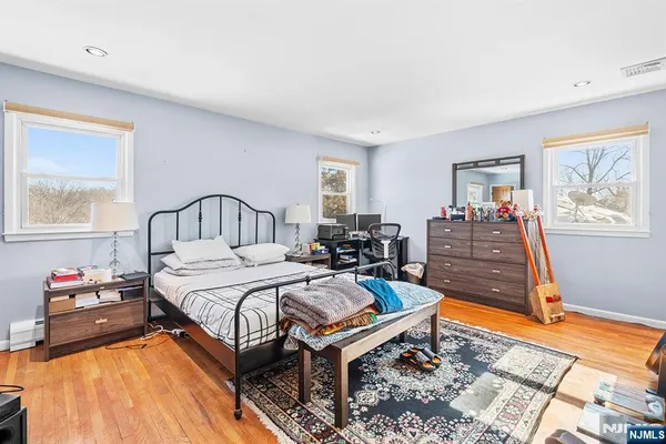 a bedroom with a bed window and dresser