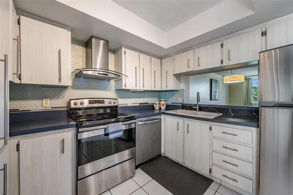 a kitchen with white cabinets and appliances