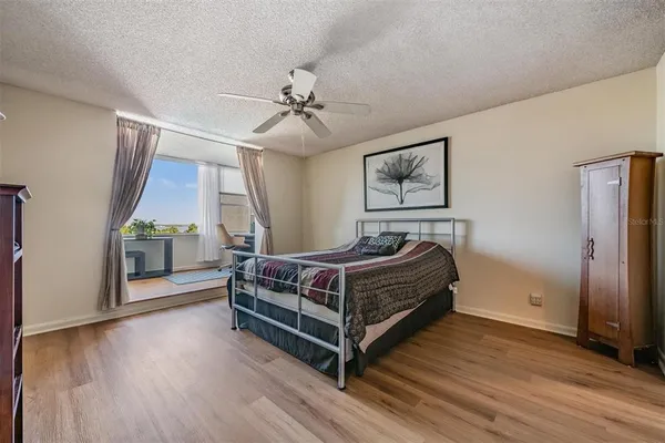 a bed sitting in a spacious bedroom next to a window