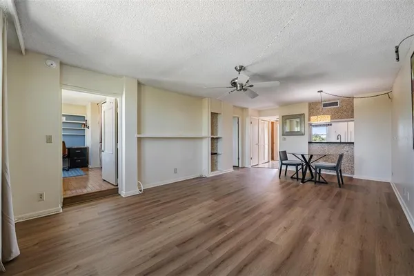 a view of an empty room with a window and wooden floor