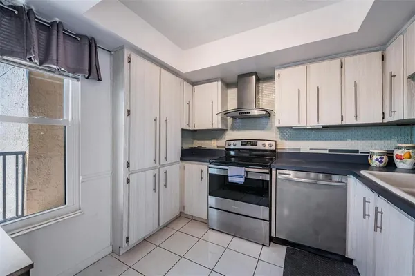a kitchen with granite countertop a refrigerator and a sink