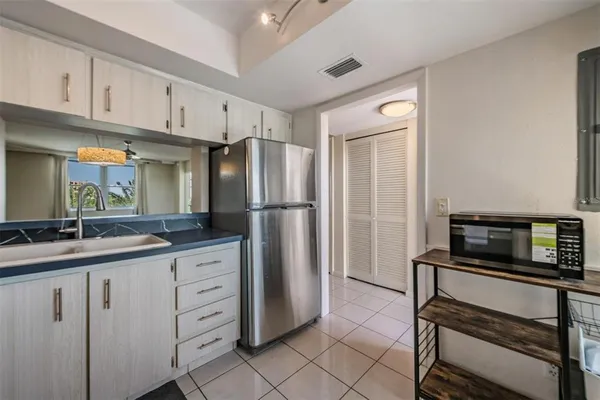 a kitchen with granite countertop white cabinets and white appliances