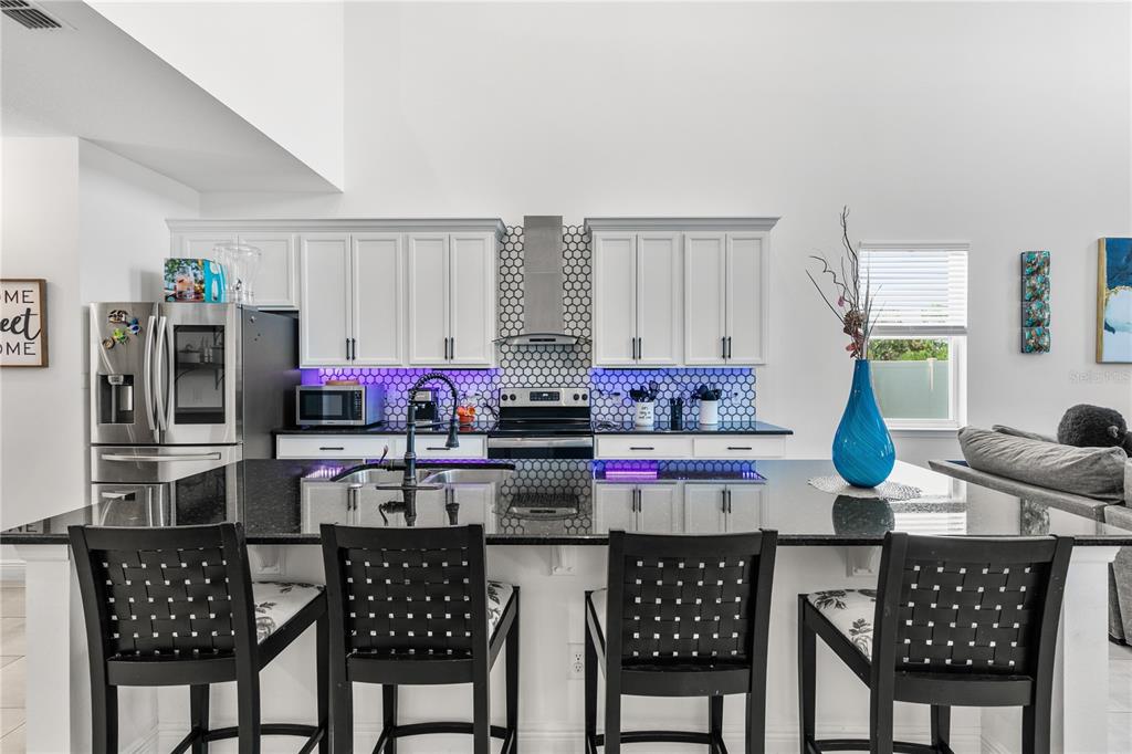 5637 Beggs Road St. Cloud, FL 34771 - Photo 2 of 35 a kitchen with stainless steel appliances kitchen island granite countertop a dining table and chairs