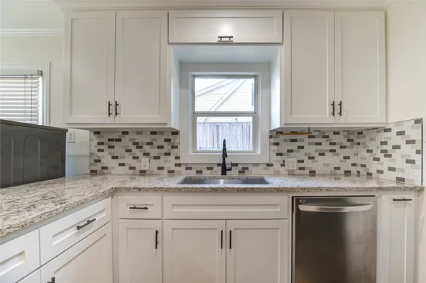 a kitchen with granite countertop a sink and cabinets