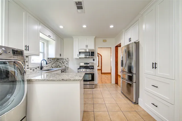 a kitchen with stainless steel appliances granite countertop a refrigerator and a sink
