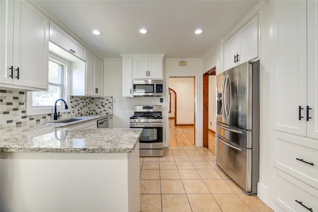 a kitchen with granite countertop a refrigerator and a sink