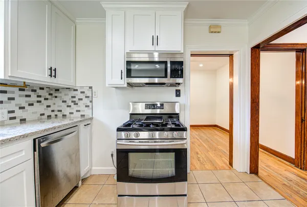 a kitchen with stainless steel appliances granite countertop a stove and a microwave