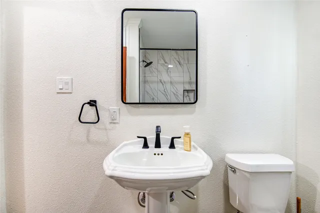 a bathroom with a toilet sink and mirror