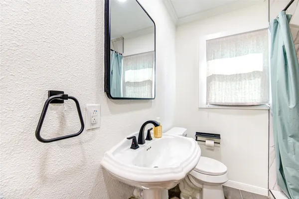 a bathroom with a sink a toilet and a mirror