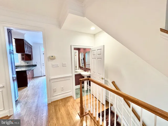 a view of an empty room with window and a kitchen view