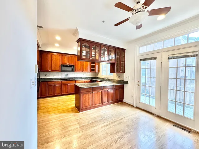 a large kitchen with stainless steel appliances granite countertop a refrigerator and a sink