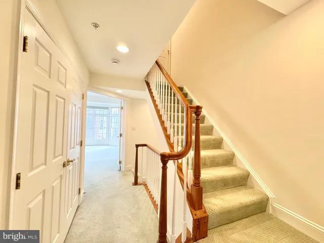 an empty room with wooden floor closet and windows