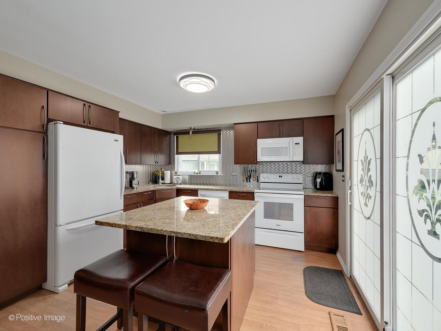 1334 Ridgefield Circle Carol Stream, IL 60188 - Photo 8 of 16 a kitchen with stainless steel appliances a stove a refrigerator a sink a dining table and chairs