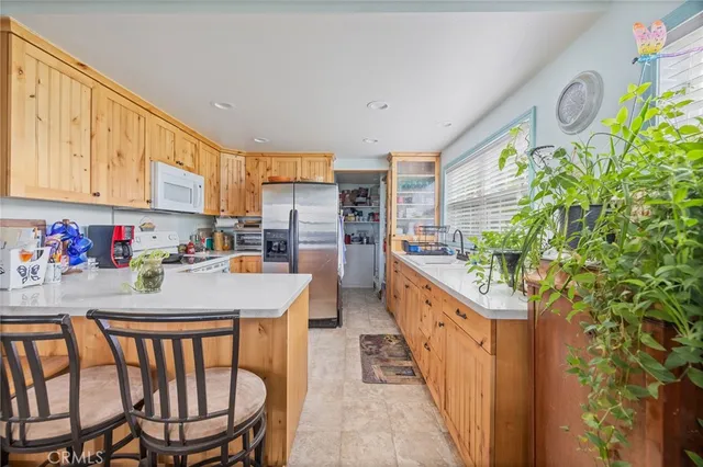 a kitchen with stainless steel appliances kitchen island granite countertop a table chairs in it and wooden floor