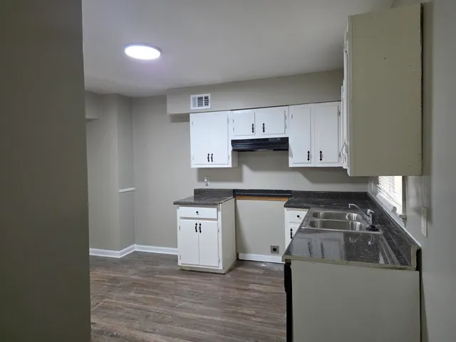 a kitchen with granite countertop a sink and a stove top oven