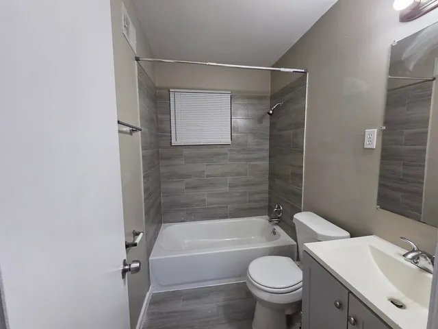 a bathroom with a granite countertop toilet sink and shower