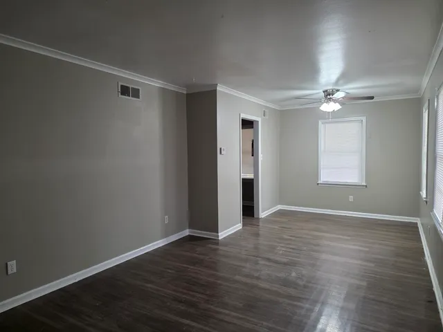 a view of an empty room with wooden floor