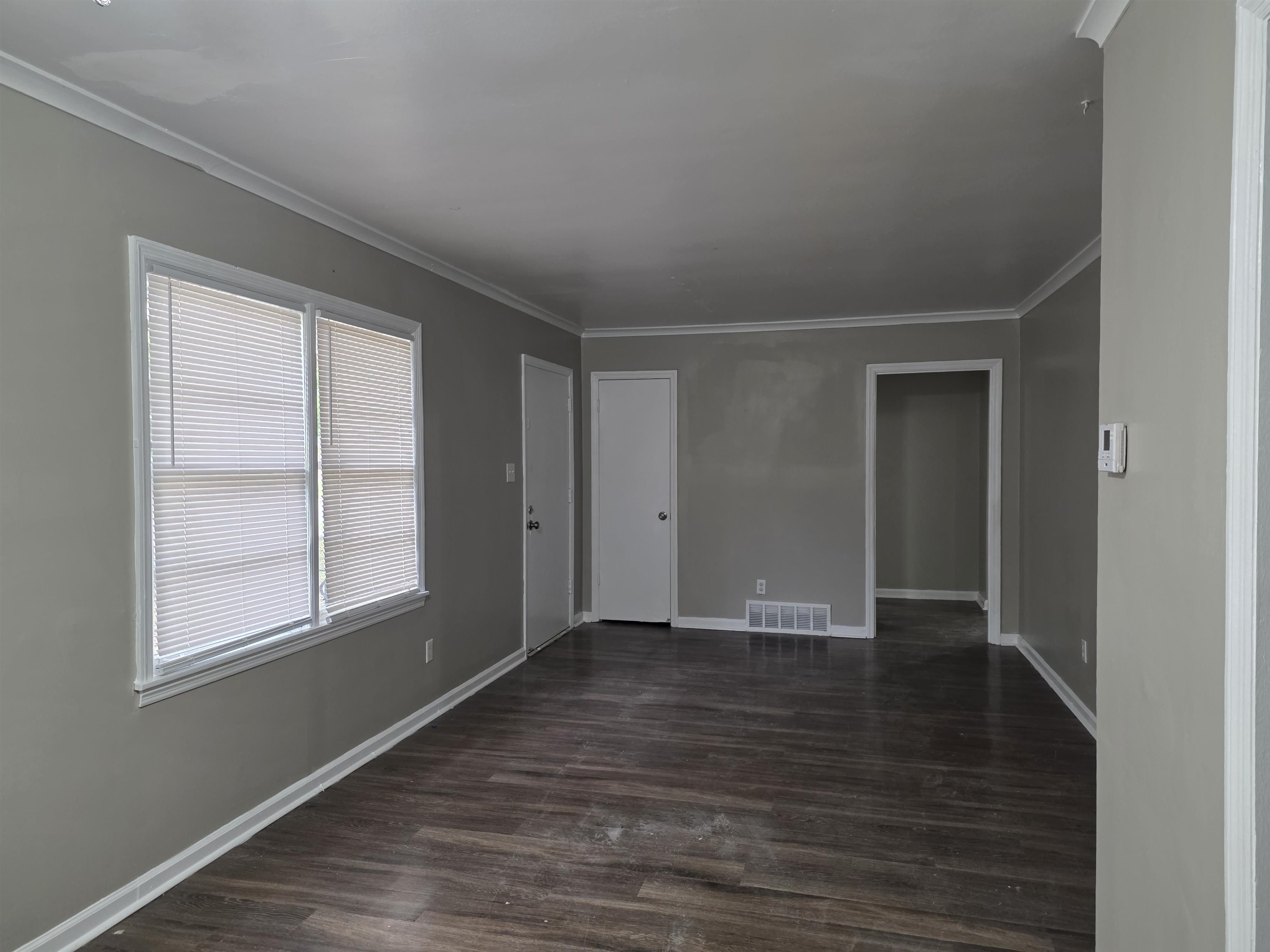 3602 Gowan Drive Memphis, TN 38127 - Photo 5 of 20 a view of an empty room with wooden floor and a window