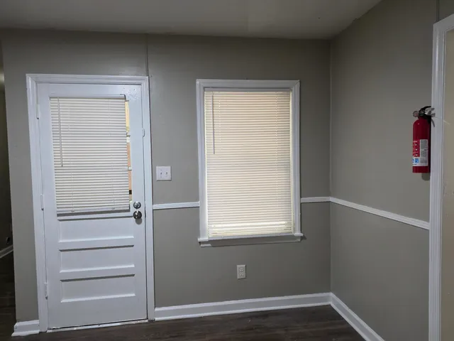 a view of an empty room with wooden floor and closet