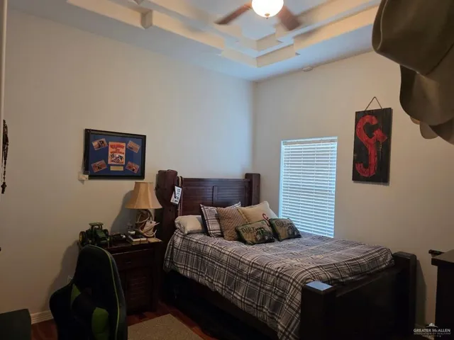 a bedroom with bed a desk and chair with the bookshelf