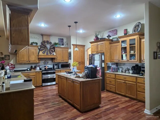 a kitchen with stainless steel appliances kitchen island granite countertop a stove and a sink