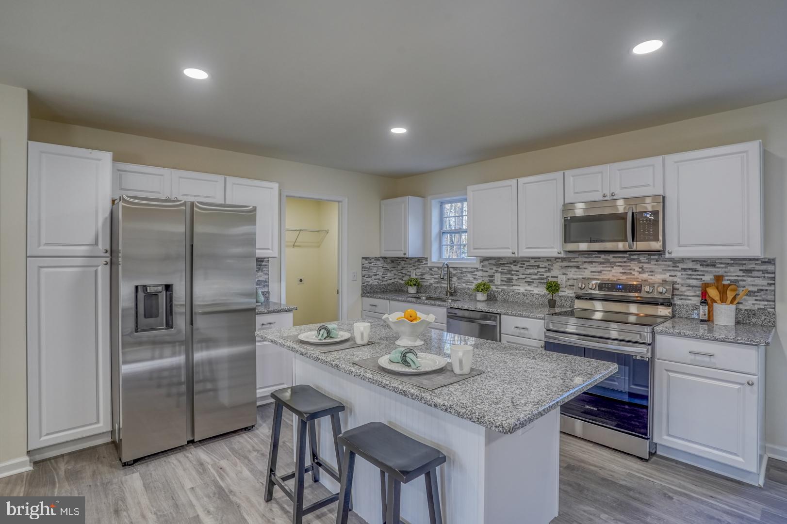 4366 Deep Grass Lane Houston, DE 19954 - Photo 7 of 28 a kitchen with stainless steel appliances granite countertop a sink a stove a refrigerator and cabinets
