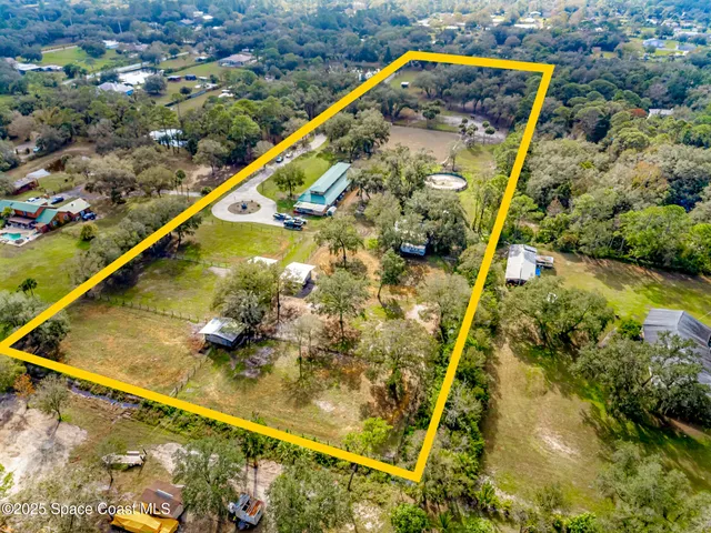a view of a swimming pool with a yard and plants