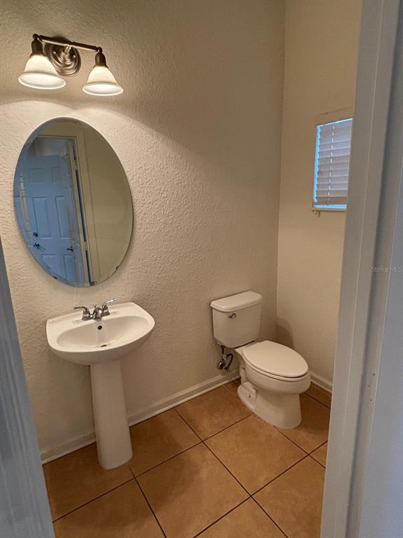 1215 Shallcross Avenue Orlando, FL 32828 - Photo 19 of 44 a bathroom with a toilet sink and mirror