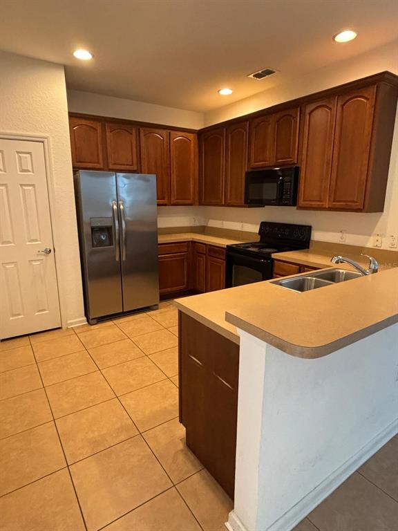 1215 Shallcross Avenue Orlando, FL 32828 - Photo 20 of 44 a kitchen with stainless steel appliances a refrigerator a stove a sink and a counter top