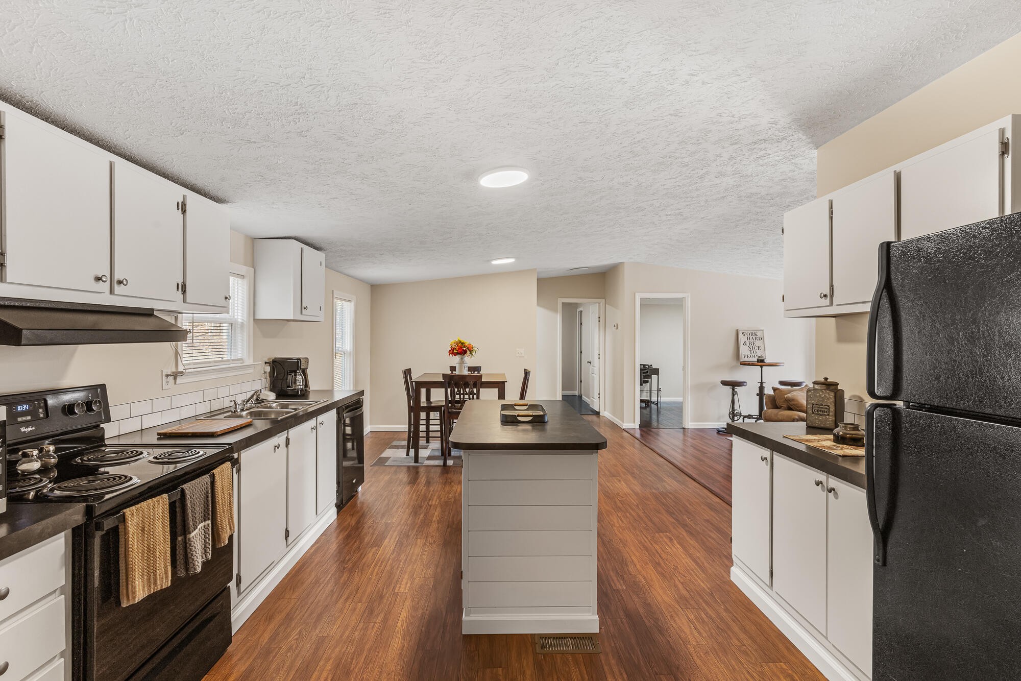 185 Bivens Road Tellico Plains, TN 37385 - Photo 17 of 34 a kitchen with stainless steel appliances a stove a sink a refrigerator white cabinets and wooden floor
